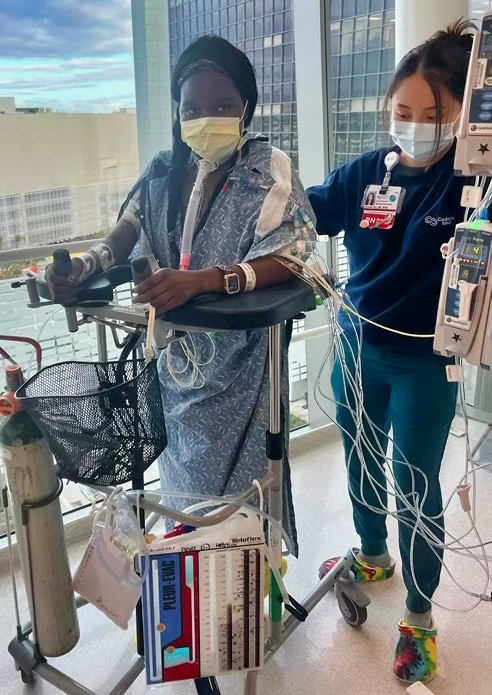 Patient and nurse walking hospital hallway