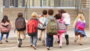 A group of children running to class.