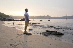 Man explores beach at sunrise