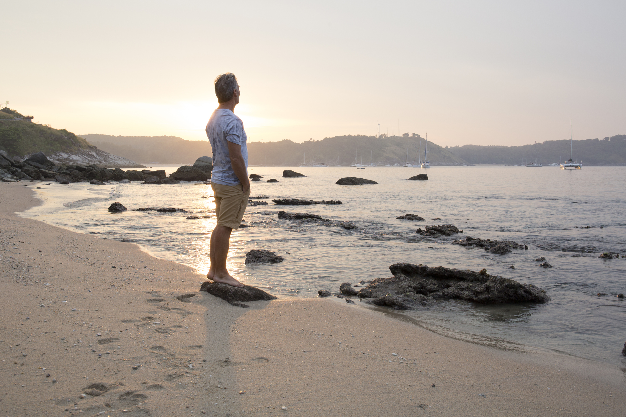 Man explores beach at sunrise