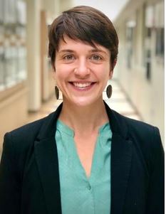 woman with short hair in a teal shirt and blazer