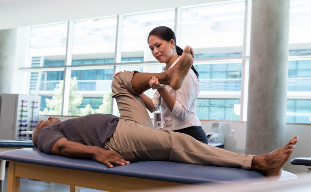 Therapist helping man stretch