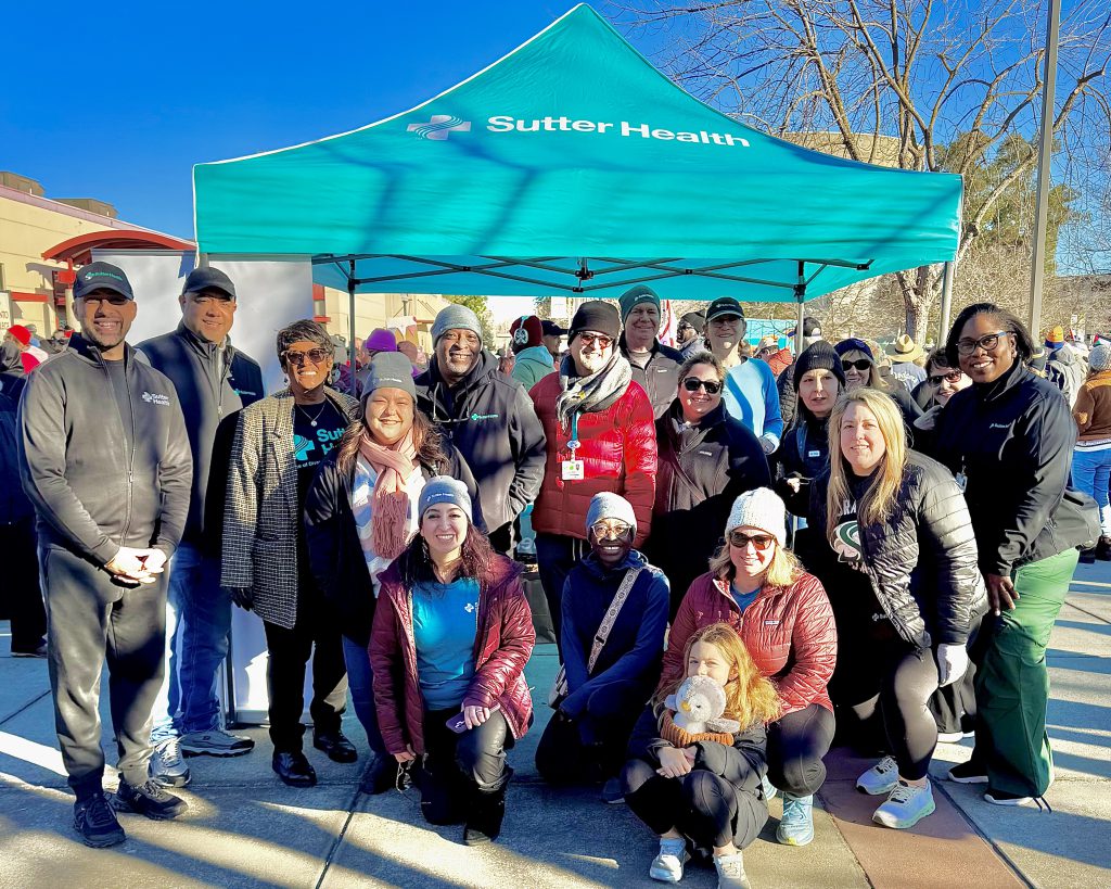 Sutter Health employees gather around the organization's booth prior to the MLK march.