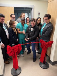 a photo of employees and physicians cutting the ribbon to celebrate opening a new exam area.