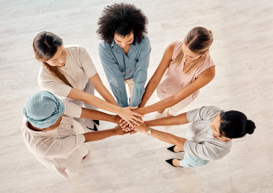 Five women join hands to demonstrate unity.