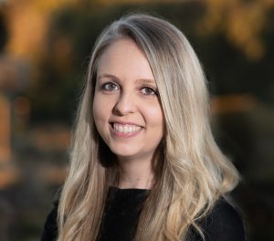 Headshot of Dr. Dr. Anne Marie Barrette, standing in front of an outside background