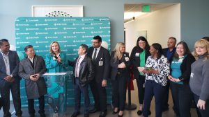 a group of employees standing at the podium being recognized for their work at a new health care center