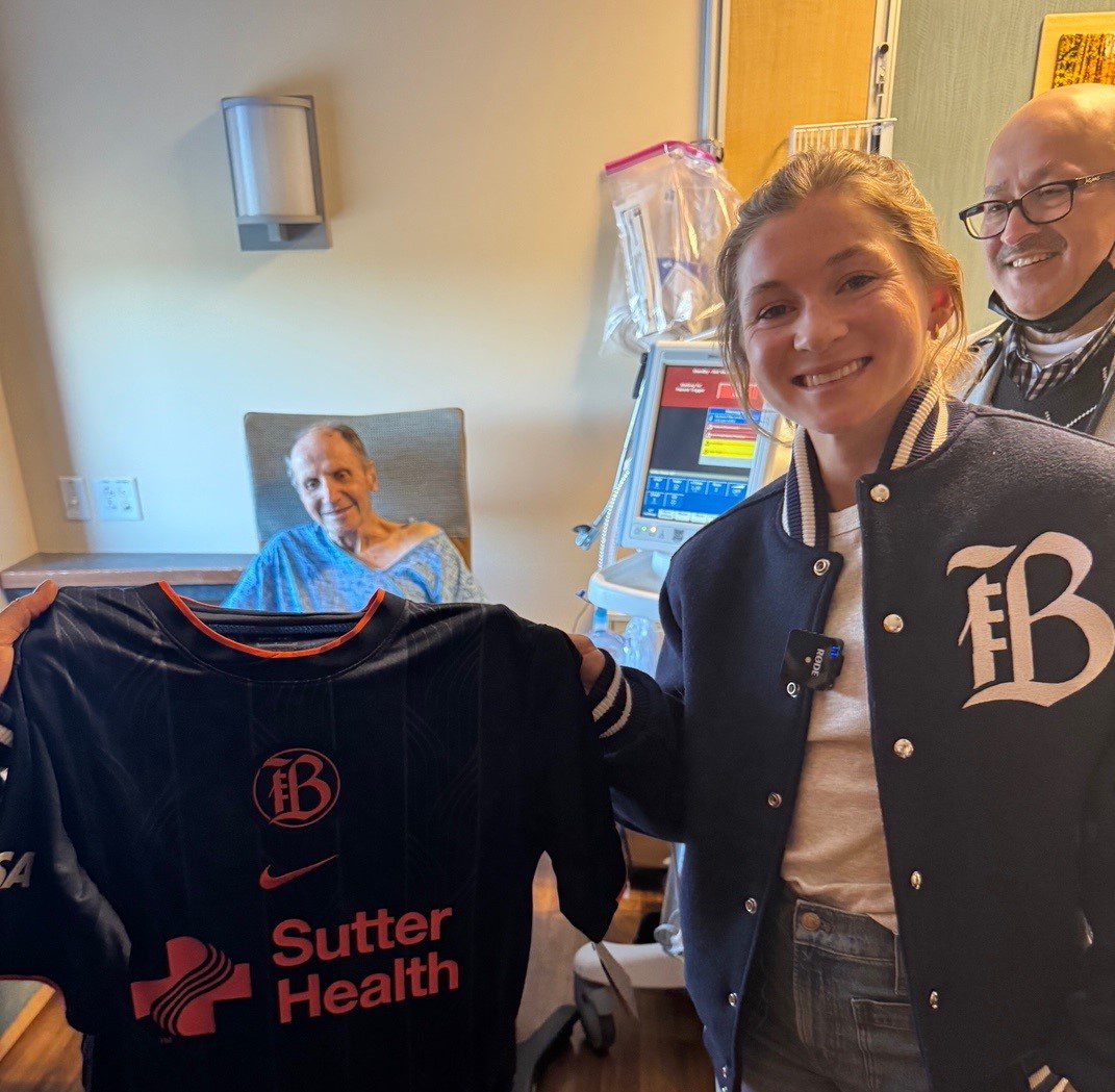 Bay FC player Maddie Moreau presents a jersey to a patient at Mills-Peninsula Medical Center