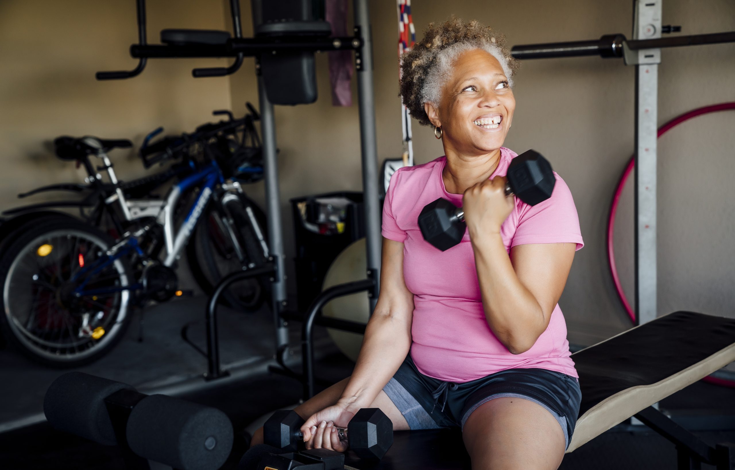Black woman lifting weights in garage
