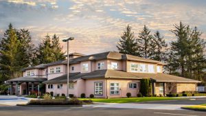 Two-story medical office building in rural setting with sunrise behind it