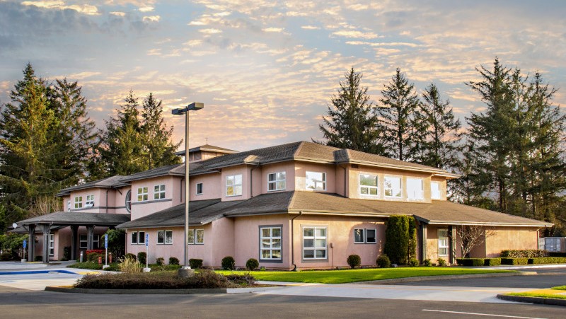 Two-story medical office building in rural setting with sunrise behind it