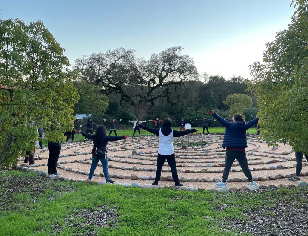 A group of female nurses stands around a labyrinth.