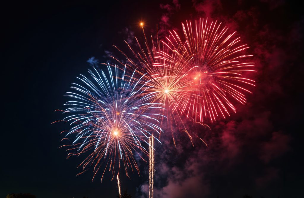 Red, white and blue fireworks display in night sky