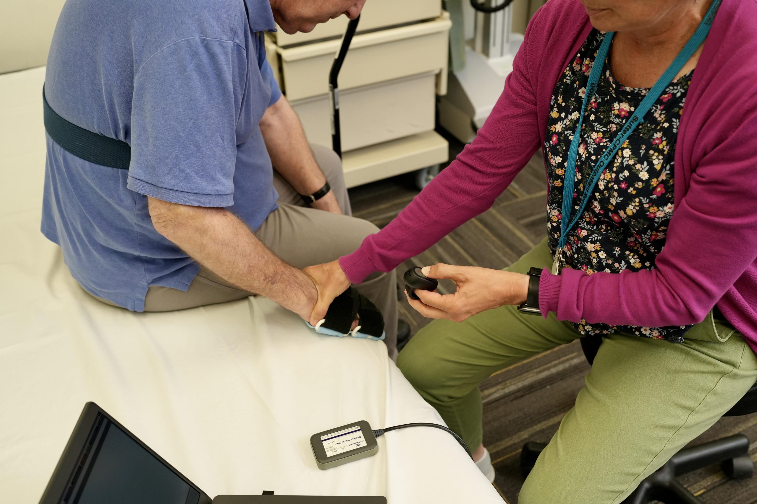 physical therapist places a hand on a patient during a therapy appointment