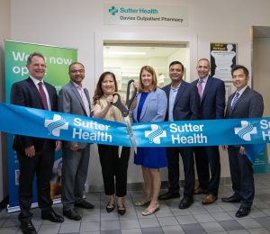 People stand together in a ceremonial ribbon cutting