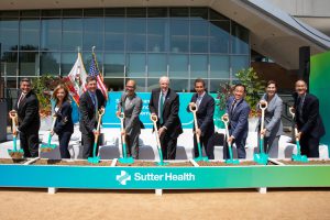 A group gathers with shovels in the ground for a ceremonial groundbreaking
