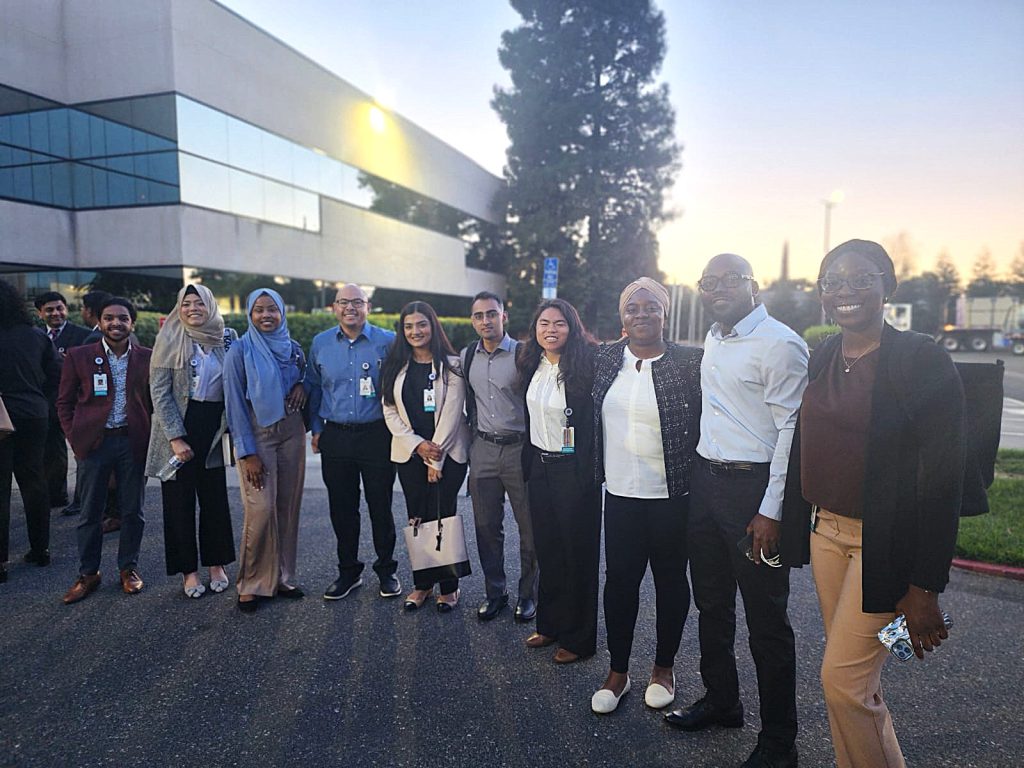 Group of new incoming residents smile for a picture outside of a building for new resident orientation