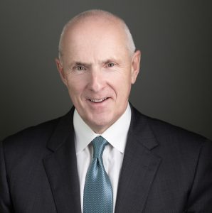 Headshot of man in suit with blue tie