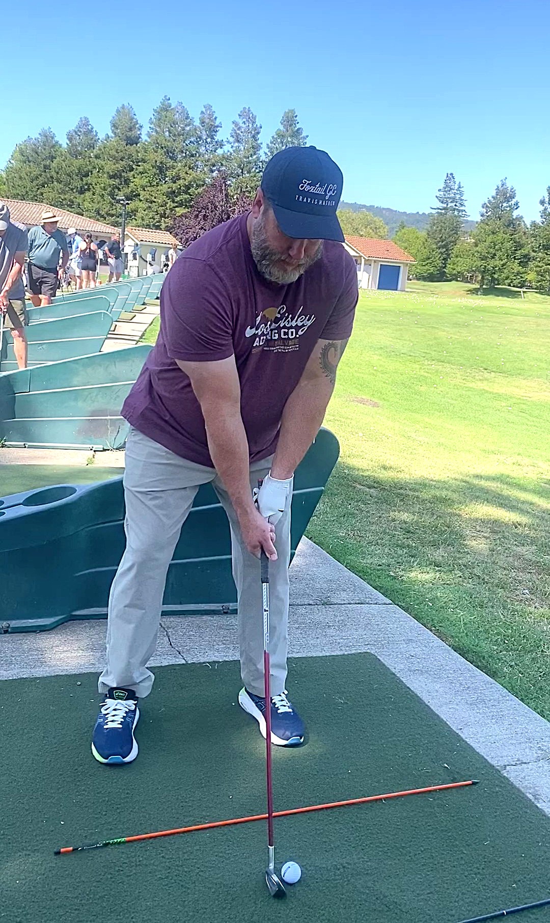 a man prepares to swing a golf club at a driving range