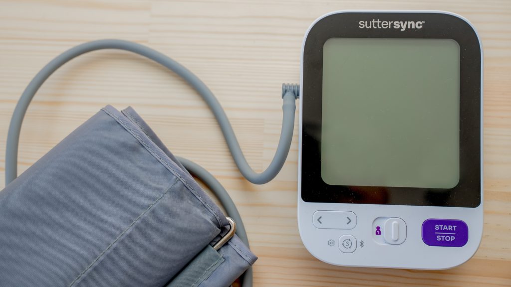 Overhead view of a blood pressure cuff and monitor lying on a table