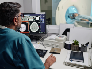 Radiologist looking at brain scan, wearing teal scrubs