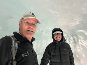 Older couple in ice cave with jackets on smiling