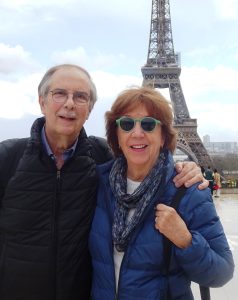A Caucasian senior male and Caucasian senior female posing in front of the Eiffel Tower