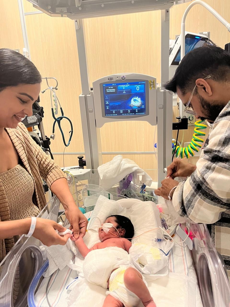 A baby in the NICU with her parents