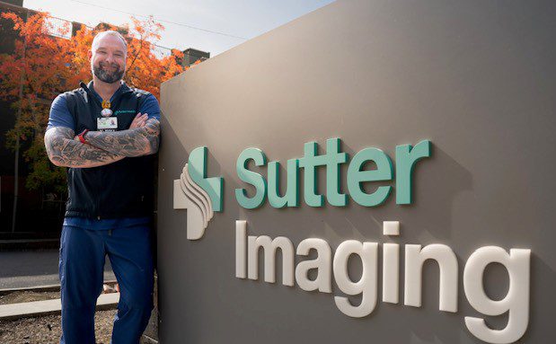 Portrait of radiologic technologist, Michael Mills, in front of a Sutter Imaging sign