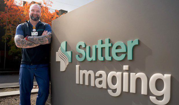 Portrait of radiologic technologist, Michael Mills, in front of a Sutter Imaging sign