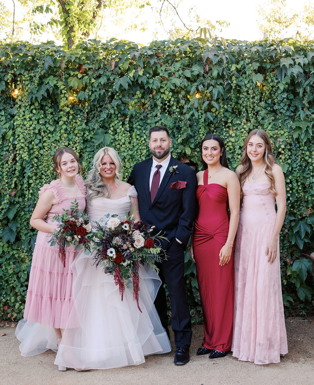 A bride, groom and family in a small wedding day photo