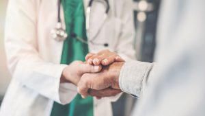 physician holding patient's hand