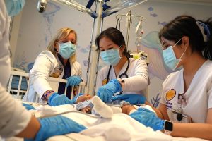 Nursing students and instructor participate in a pediatric nursing simulation