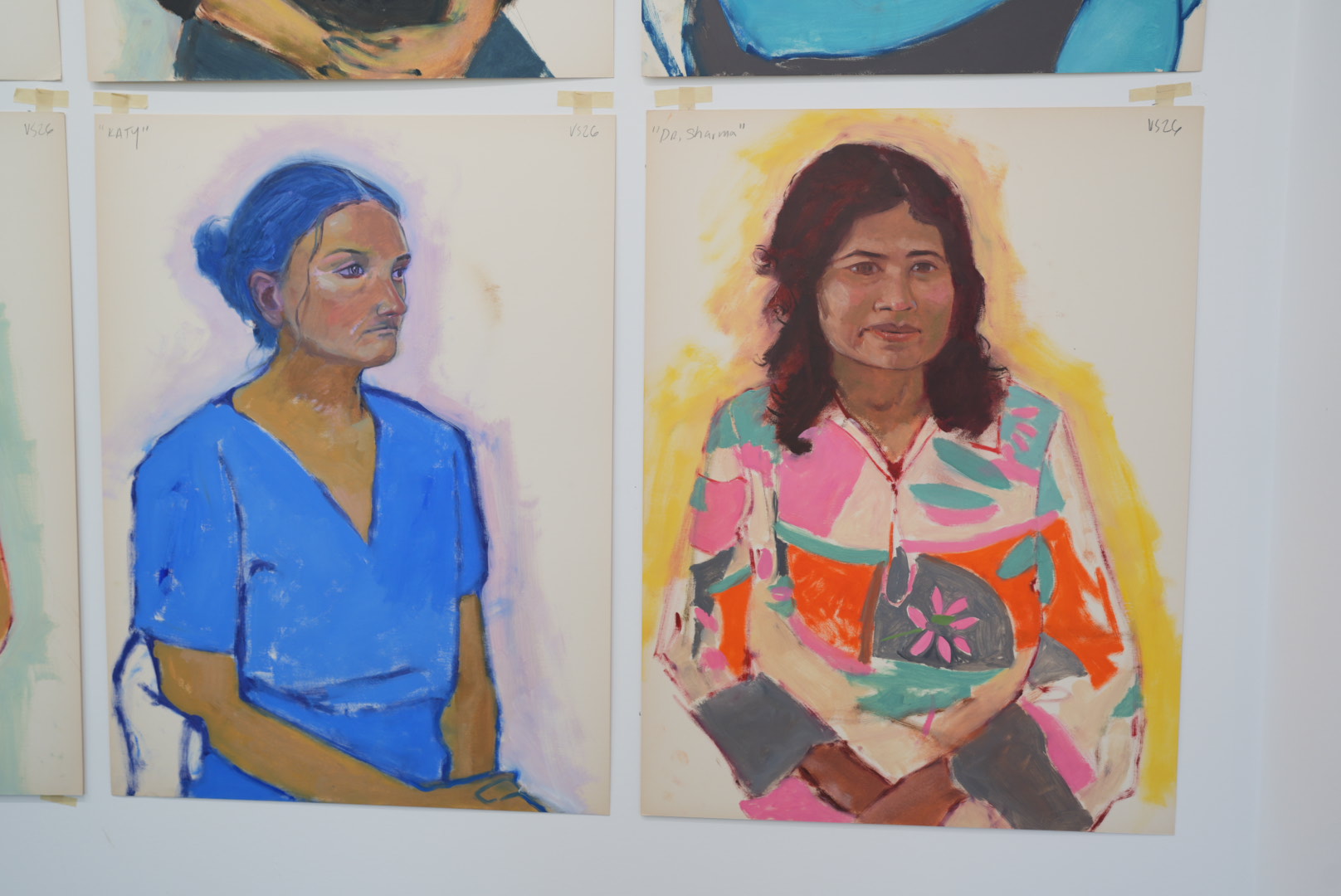 two colorful portraits hang on a wall