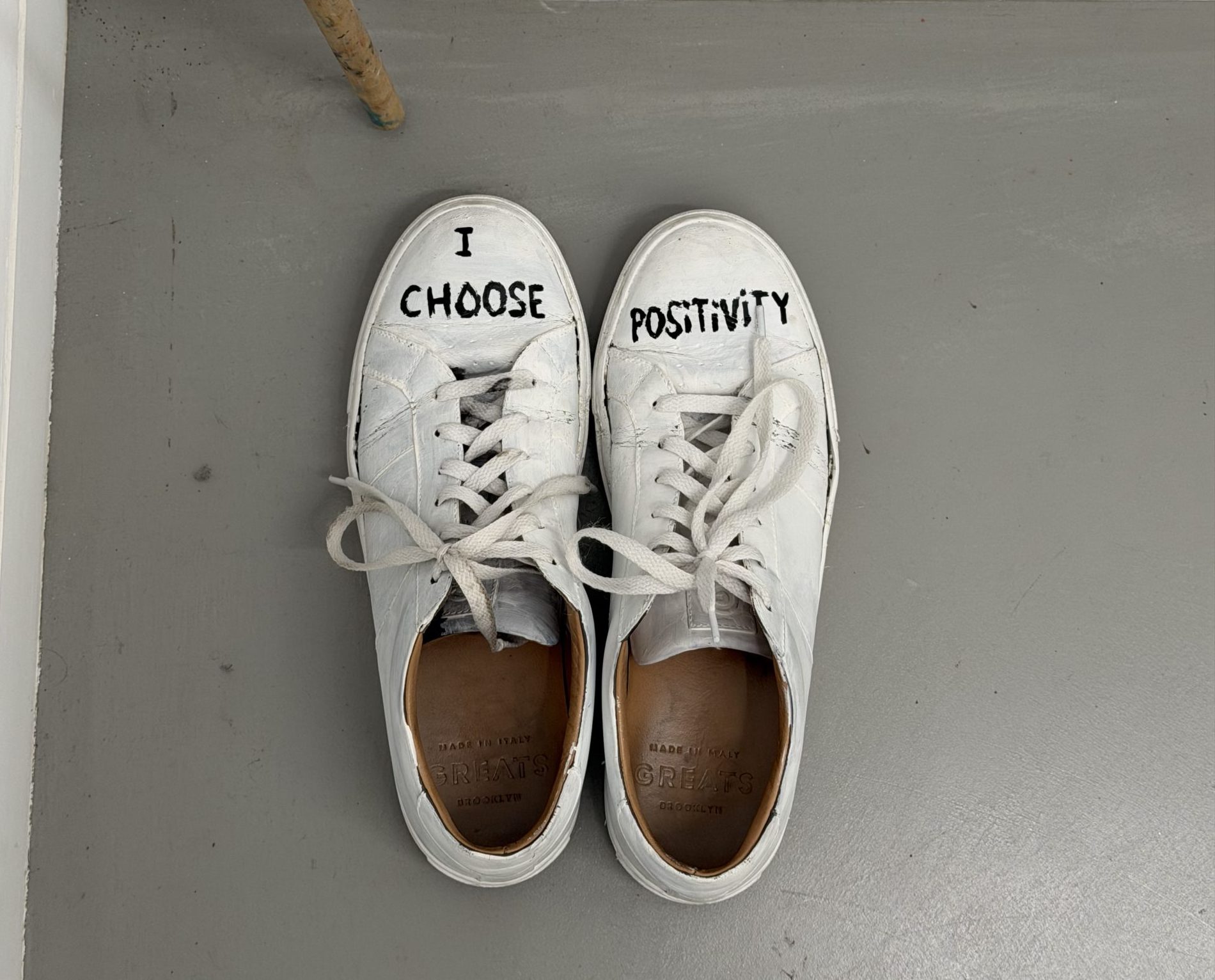 White shoes with the writing "I Choose Positivity" on them