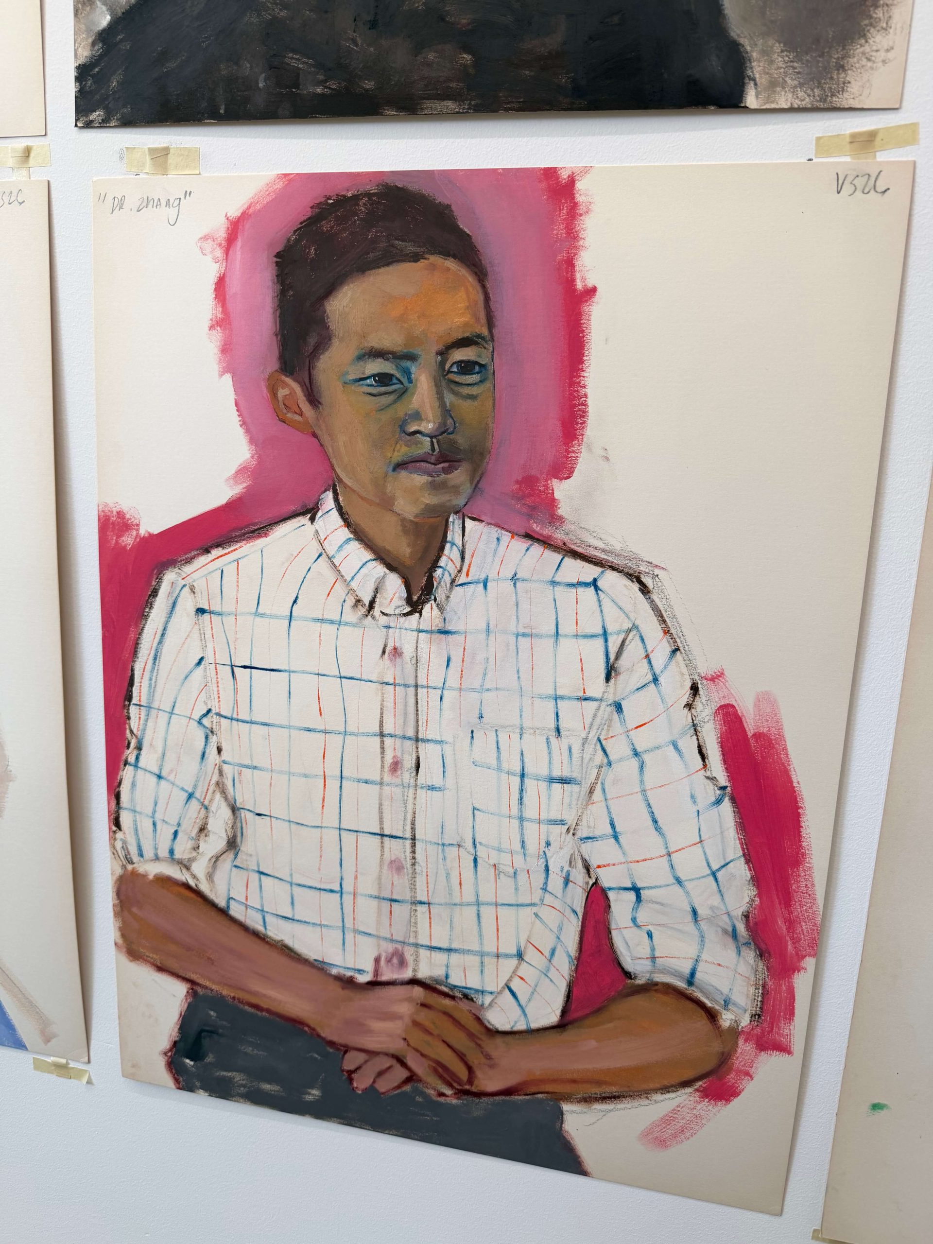 A woman stands next to her painted portrait 