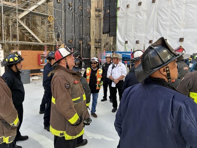 Fire crew members stand inside a construction site