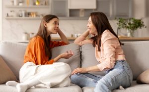 teen and mother talking on their couch