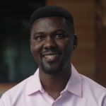 Male doctor, in pink button up shirt, smiling