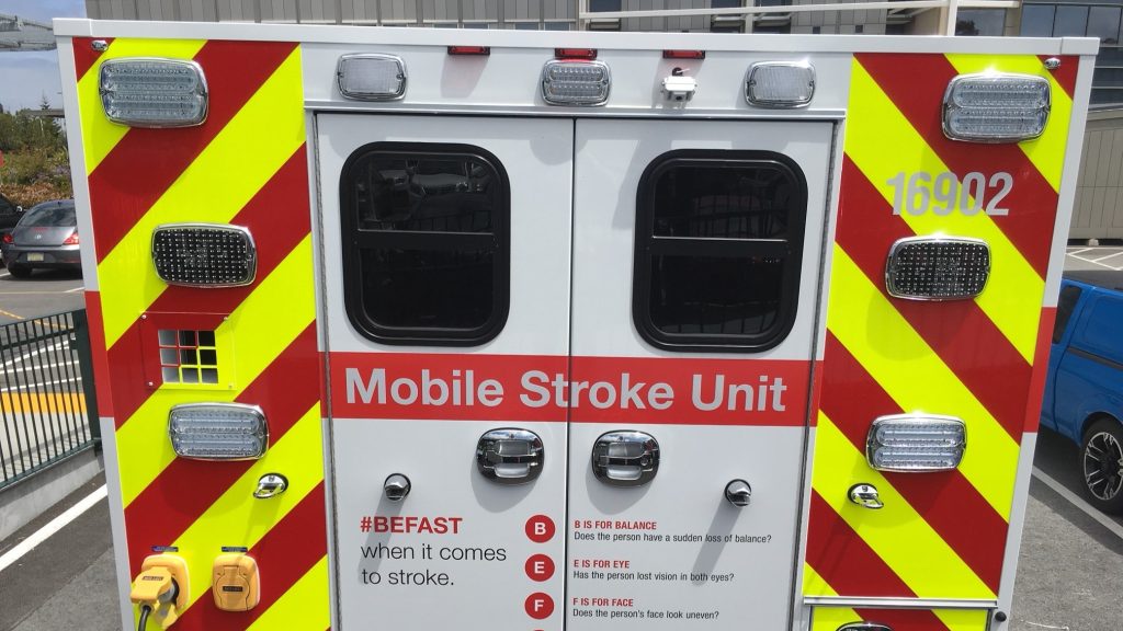 Rear doors of specialized ambulance highlighted with bright red and fluorescent yellow stripes