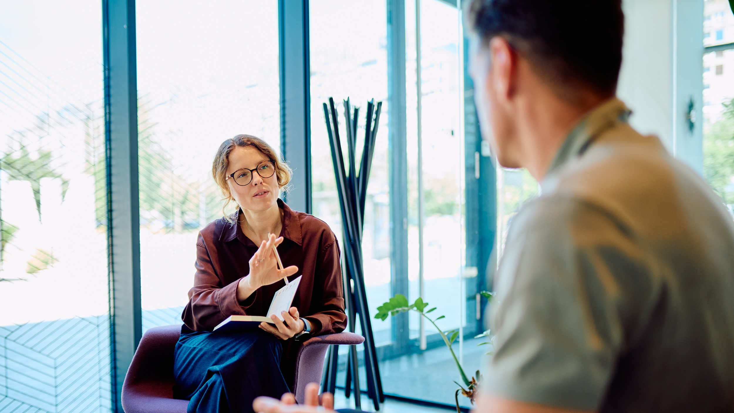 Psychiatry consult Female professional giving guidance and support to a man during a therapy session in a modern office setup