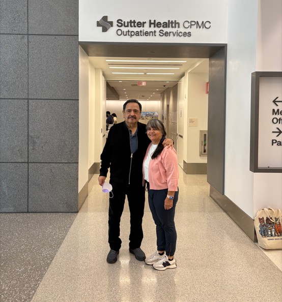 A couple stand together in a medical center lobby