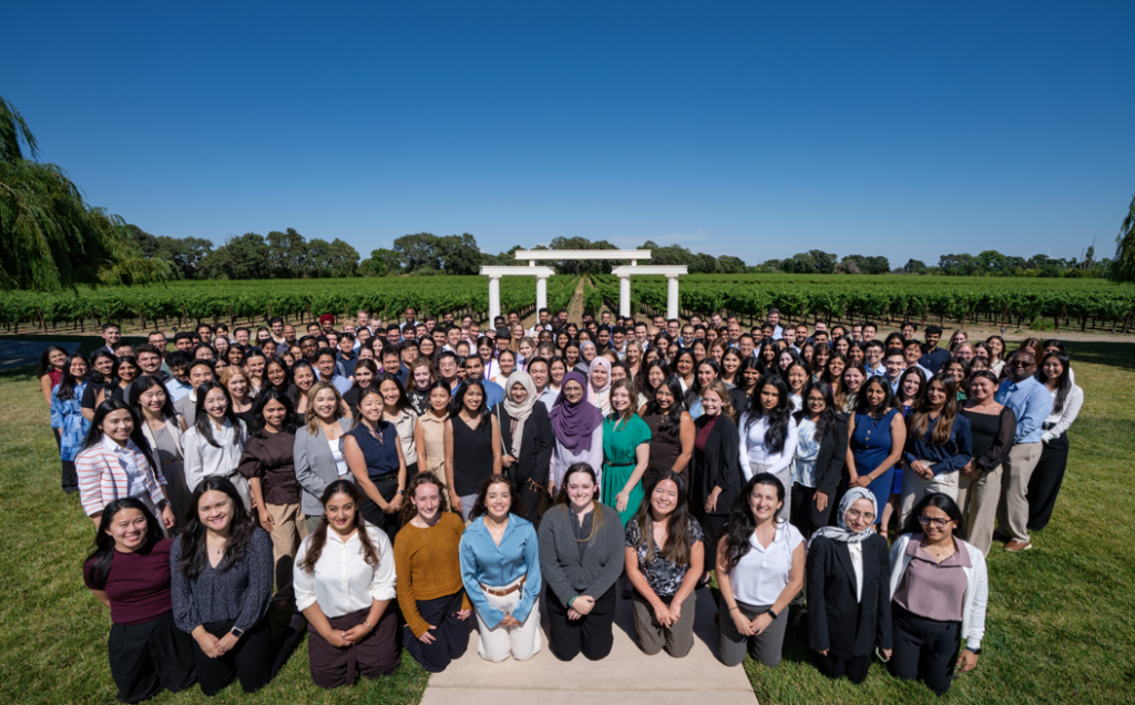 Group of residents at orientation day, smiling in front of vineyard