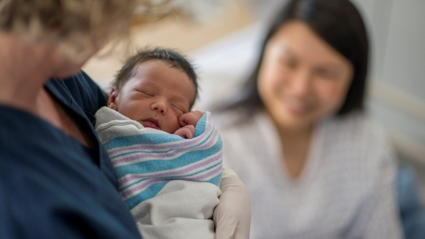 Newborn baby being held