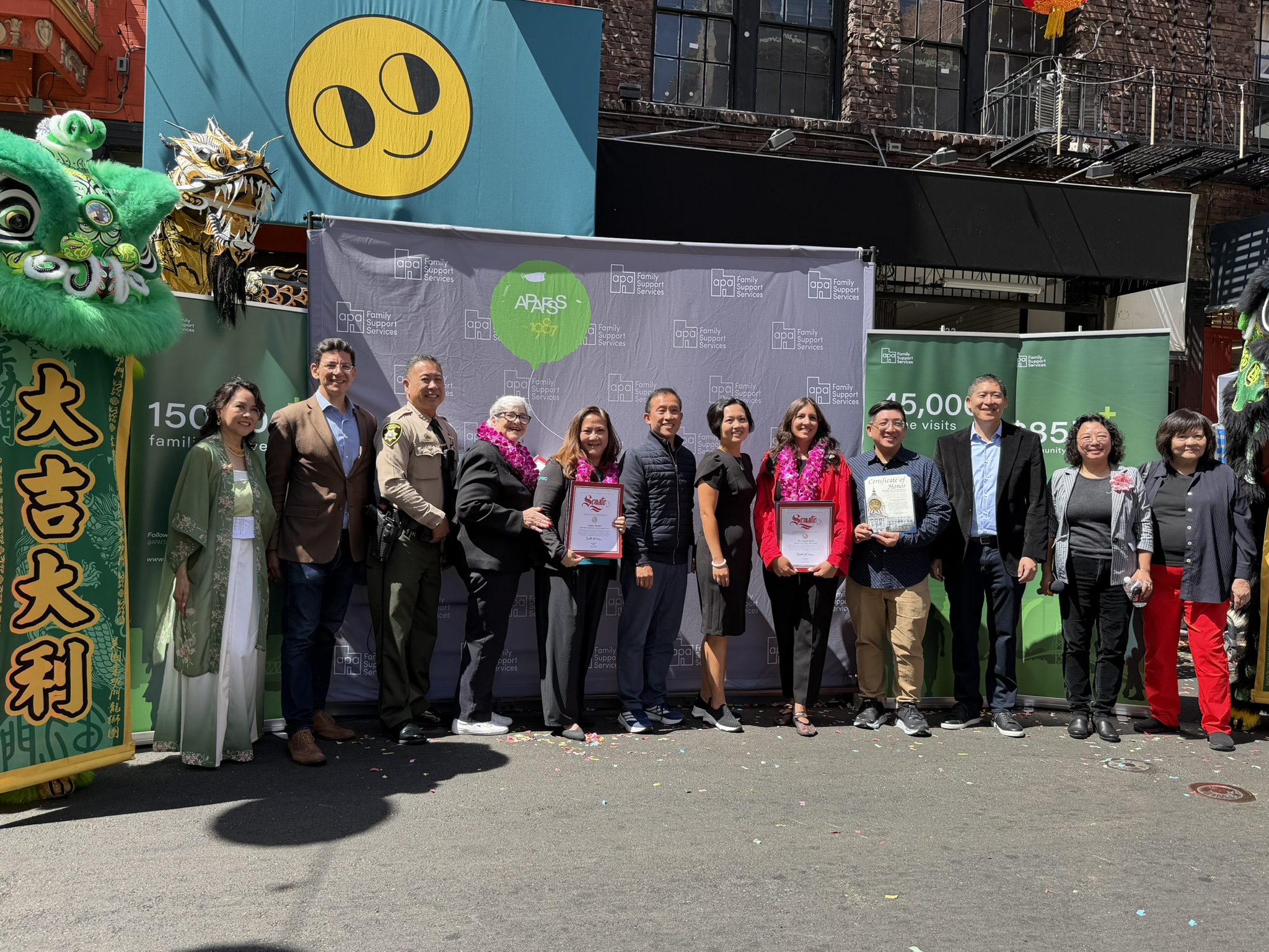 Several people pose for a picture in front of a banner