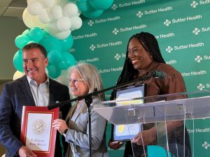Kevin Cook, president of the Sutter Health Greater Silicon Valley Division, accepts certificates from Tamara Dehnert, district representative with California State Senator Jerry McNerney's office, and Ebony Odior, district representative from Assemblymember Liz Ortega's office.
