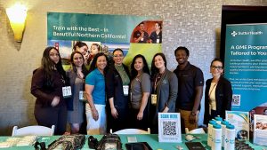 Group of people smiling in front of a booth like table