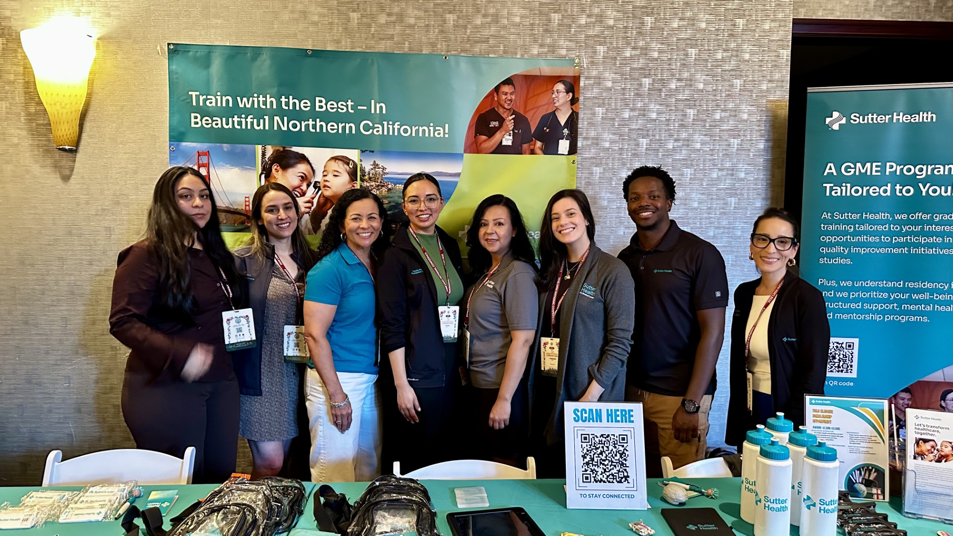 LMSA Conference Group of people smiling in front of a booth like table