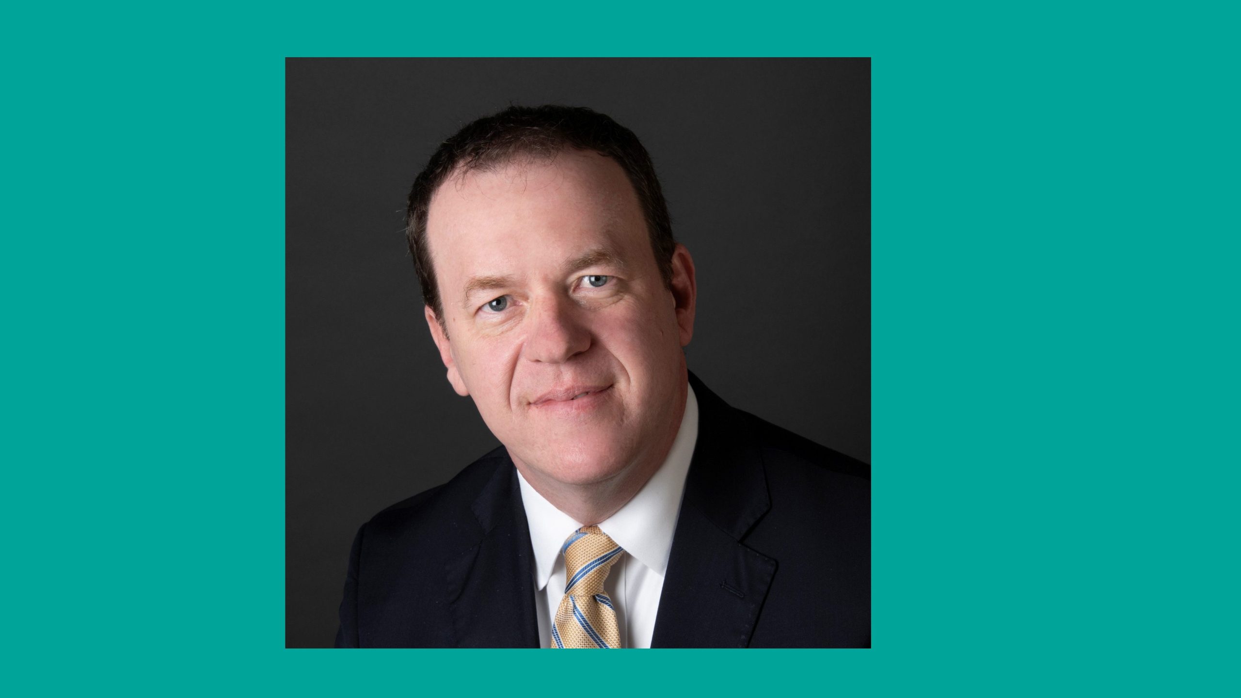 Brad Goodson Man in suit and tie with teal border around photo