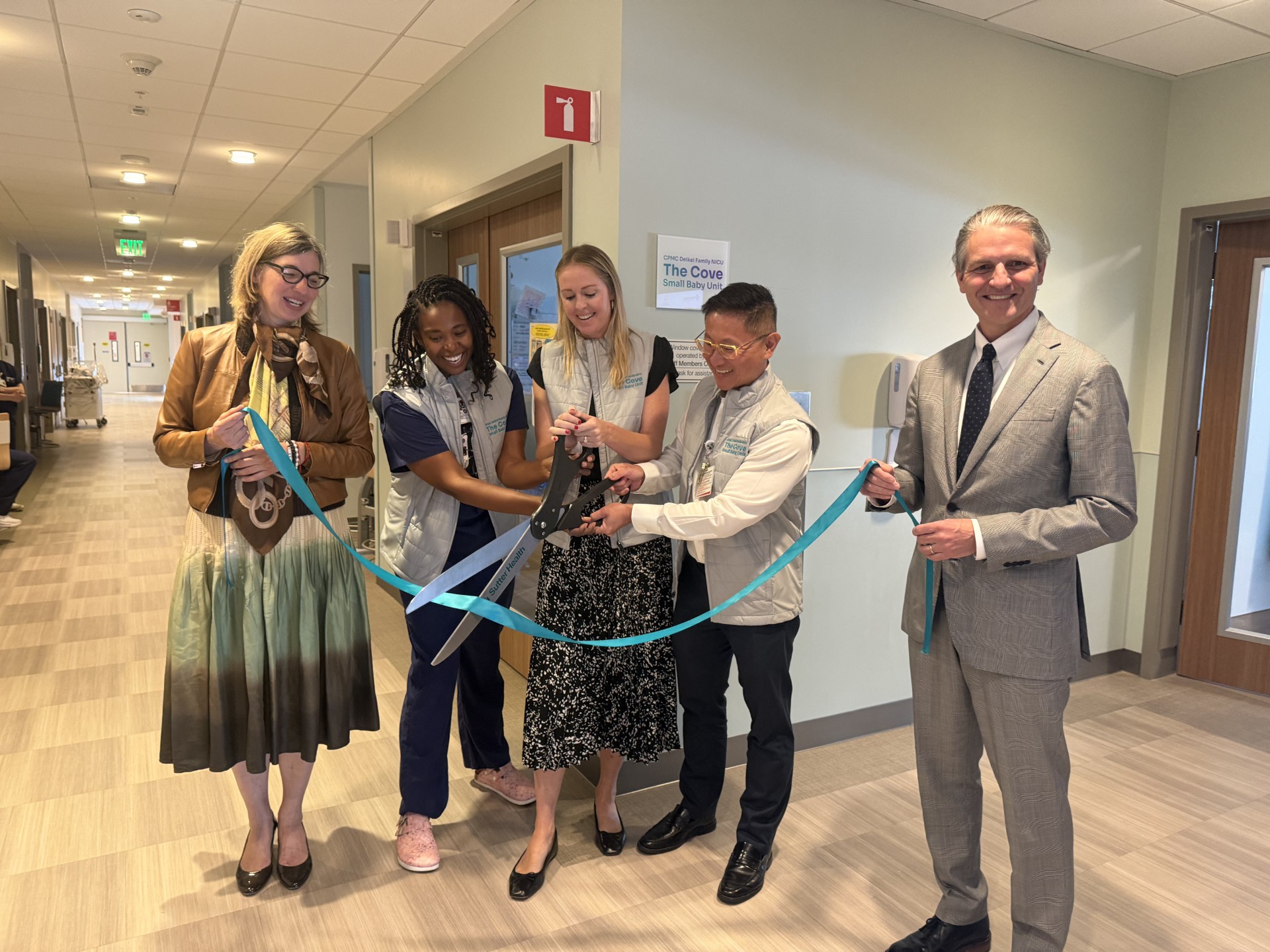 A group cuts a ribbon